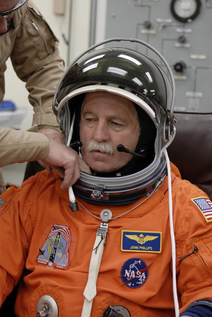 CAPE CANAVERAL, Fla. –   At NASA's Kennedy Space Center in Florida, STS-119 Mission Specialist John Phillips is fitted with the helmet for his launch-and-entry suit before heading to Launch Pad 39A for a simulated launch countdown. The astronauts are at Kennedy to prepare for launch through Terminal Countdown Demonstration Test activities. The TCDT includes equipment familiarization and emergency egress training. The crew is targeted to launch on the STS-119 mission Feb. 12 on space shuttle Discovery. During the 14-day mission, the crew will install the S6 truss segment and solar arrays to the starboard side of the International Space Station, completing the station's truss, or backbone.    Photo credit: NASA/Kim Shiflett