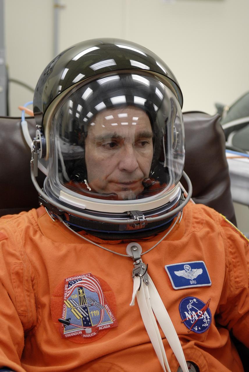CAPE CANAVERAL, Fla. –   At NASA's Kennedy Space Center in Florida, STS-119 Commander Lee Archambault tries on his helmet to complete the launch-and-entry suit before heading to Launch Pad 39A for a simulated launch countdown. The astronauts are at Kennedy to prepare for launch through Terminal Countdown Demonstration Test activities. The TCDT includes equipment familiarization and emergency egress training. The crew is targeted to launch on the STS-119 mission Feb. 12 on space shuttle Discovery. During the 14-day mission, the crew will install the S6 truss segment and solar arrays to the starboard side of the International Space Station, completing the station's truss, or backbone.    Photo credit: NASA/Kim Shiflett