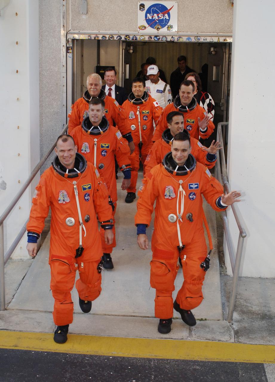 CAPE CANAVERAL, Fla. – Wearing their launch-and-entry suits, the STS-119 crew members leave the Operations and Checkout Building at NASA's Kennedy Space Center in Florida to head for Launch Pad 39A and a simulated launch countdown. Clockwise from left are Pilot Tony Antonelli, Mission Specialists Steve Swanson, John Phillips, Koichi Wakata, Richard Arnold and Joseph Acaba, and Commander Lee Archambault. The astronauts are at Kennedy to prepare for launch through Terminal Countdown Demonstration Test activities. The TCDT includes equipment familiarization and emergency egress training. The crew is targeted to launch on the STS-119 mission Feb. 12 on space shuttle Discovery. During the 14-day mission, the crew will install the S6 truss segment and solar arrays to the starboard side of the International Space Station, completing the station's truss, or backbone. Photo credit: NASA/Kim Shiflett