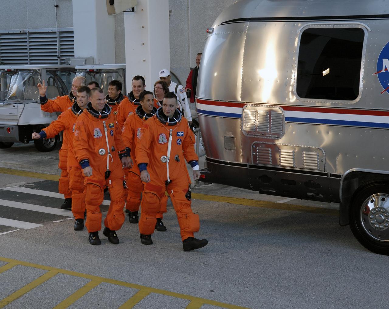 CAPE CANAVERAL, Fla. – At NASA's Kennedy Space Center in Florida, the STS-119 crew members head for the Astrovan and a ride to Launch Pad 39A for a simulated launch countdown. Commander Lee Archambault leads the way; seen behind him, on the left, are Mission Specialists John Phillips and Steve Swanson and Pilot Tony Antonelli. In the back, from center, are Mission Specialists Koichi Wakata, Richard Arnold and Joseph Acaba. The astronauts are at Kennedy to prepare for launch through Terminal Countdown Demonstration Test activities. The TCDT includes equipment familiarization and emergency egress training. The crew is targeted to launch on the STS-119 mission Feb. 12 on space shuttle Discovery. During the 14-day mission, the crew will install the S6 truss segment and solar arrays to the starboard side of the International Space Station, completing the station's truss, or backbone. Photo credit: NASA/Kim Shiflett