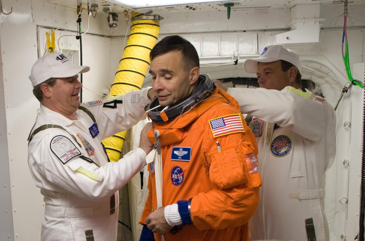 CAPE CANAVERAL, Fla. –  In the White Room on Launch Pad 39A at NASA's Kennedy Space Center in Florida, STS-119 Commander Lee Archambault is helped by the Closeout Crew to put on his harness.  Archambault will enter space shuttle Discovery along with the other crew members to conduct a simulated launch countdown. The astronauts are at Kennedy to prepare for launch through Terminal Countdown Demonstration Test activities. The TCDT includes equipment familiarization and emergency egress training. Discovery is targeted to launch on the STS-119 mission Feb. 12. During the 14-day mission, the crew will install the S6 truss segment and solar arrays to the starboard side of the International Space Station, completing the station's truss, or backbone. Photo credit: NASA/Sandra Joseph, Kevin O'Connell, Tom Farrar