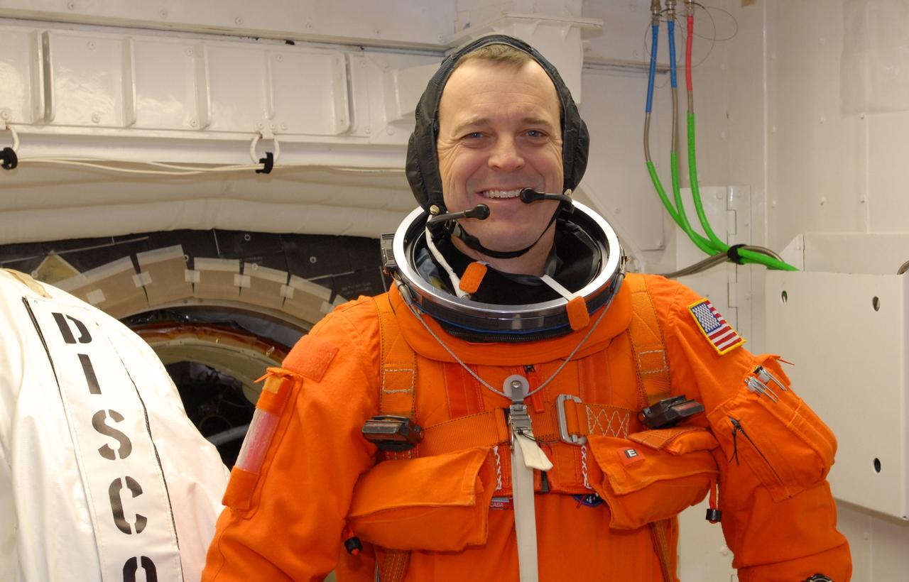 CAPE CANAVERAL, Fla. –  In the White Room on Launch Pad 39A at NASA's Kennedy Space Center in Florida, STS-119 Mission Specialist Richard Arnold gets ready to enter space shuttle Discovery, behind him. The White Room provides access into Discovery.  Arnold and other crew members will conduct a simulated launch countdown as part of the prelaunch preparation known as Terminal Countdown Demonstration Test. The TCDT also includes equipment familiarization and emergency egress training. Discovery is targeted to launch on the STS-119 mission Feb. 12. During the 14-day mission, the crew will install the S6 truss segment and solar arrays to the starboard side of the International Space Station, completing the station's truss, or backbone. Photo credit: NASA/Jim Grossmann