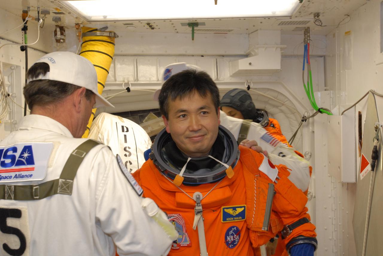 CAPE CANAVERAL, Fla. –  In the White Room on Launch Pad 39A at NASA's Kennedy Space Center in Florida, STS-119 Mission Specialist Koichi Wakata is helped by the Closeout Crew to put on his harness.  The White Room provides access into space shuttle Discovery.  Wakata and other crew members will conduct a simulated launch countdown as part of the prelaunch preparation known as Terminal Countdown Demonstration Test. The TCDT also includes equipment familiarization and emergency egress training. Discovery is targeted to launch on the STS-119 mission Feb. 12. During the 14-day mission, the crew will install the S6 truss segment and solar arrays to the starboard side of the International Space Station, completing the station's truss, or backbone. Photo credit: NASA/Jim Grossmann