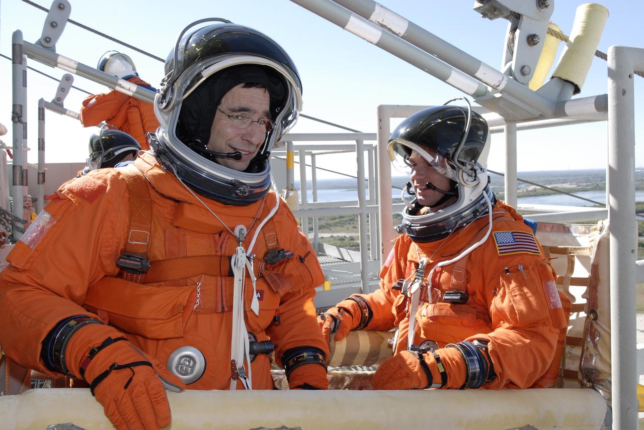 CAPE CANAVERAL, Fla. –  Following the simulated launch countdown on Launch Pad 39A at NASA's Kennedy Space Center in Florida, STS-119 Commander Lee Archambault and Pilot Tony Antonelli take seats in the slidewire basket used for emergency egress from the pad.  The practice egress is part of the prelaunch preparation known as Terminal Countdown Demonstration Test.  The TCDT also includes equipment familiarization. Discovery is targeted to launch on the STS-119 mission Feb. 12. During the 14-day mission, the crew will install the S6 truss segment and solar arrays to the starboard side of the International Space Station, completing the station's truss, or backbone. Photo credit: NASA/Kim Shiflett