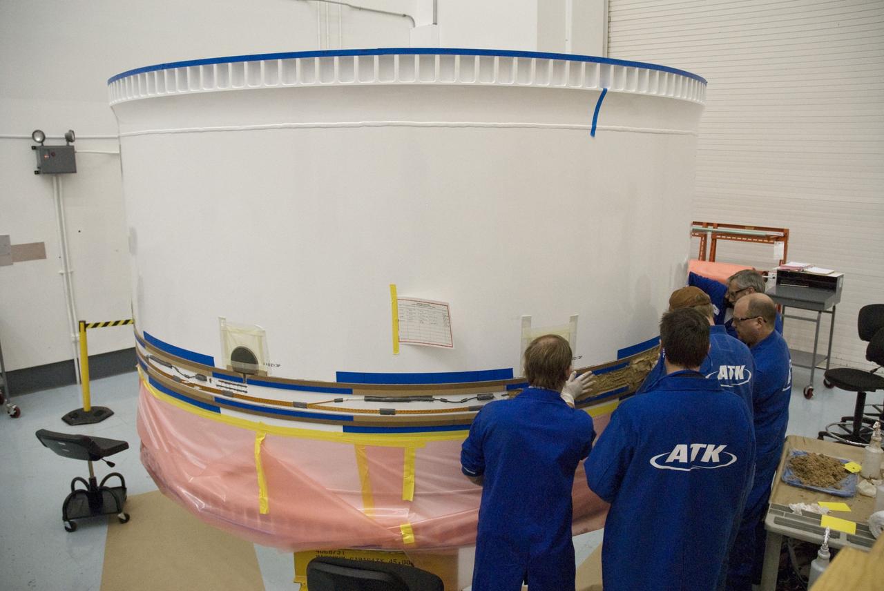 CAPE CANAVERAL, Fla. –    At Astrotech in Titusville, Fla., workers prepare forward fifth segment simulator of the Ares I-X for cork application.  Ares I-X is the test vehicle for the Ares I, which is part of the Constellation Program to return men to the moon and beyond.  Ares I is the essential core of a safe, reliable, cost-effective space transportation system that eventually will carry crewed missions back to the moon, on to Mars and out into the solar system. Ares I may also use its 25-ton payload capacity to deliver resources and supplies to the International Space Station, or to "park" payloads in orbit for retrieval by other spacecraft bound for the moon or other destinations. The Ares I-X is targeted for launch in July 2009. Photo credit: NASA/Tim Jacobs