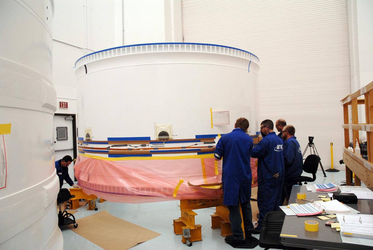 CAPE CANAVERAL, Fla. –    At Astrotech in Titusville, Fla., workers prepare forward fifth segment simulator of the Ares I-X for cork application. Ares I-X is the test vehicle for the Ares I, which is part of the Constellation Program to return men to the moon and beyond.  Ares I is the essential core of a safe, reliable, cost-effective space transportation system that eventually will carry crewed missions back to the moon, on to Mars and out into the solar system. Ares I may also use its 25-ton payload capacity to deliver resources and supplies to the International Space Station, or to "park" payloads in orbit for retrieval by other spacecraft bound for the moon or other destinations. The Ares I-X is targeted for launch in July 2009. Photo credit: NASA/Tim Jacobs