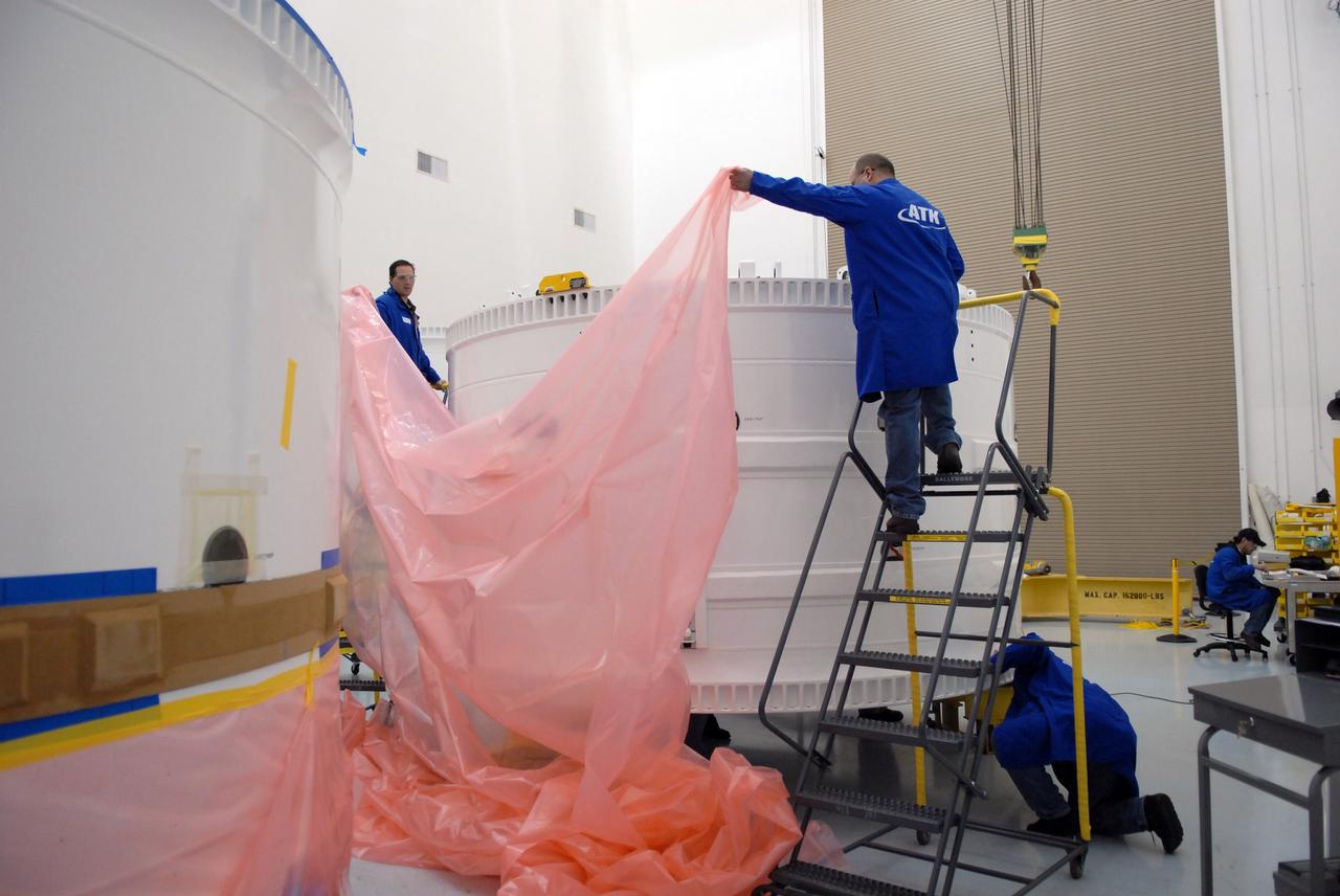 CAPE CANAVERAL, Fla. – At Astrotech in Titusville, Fla., workers place protective covers around the Ares I-X forward skirt. The segment will be transferred to the Assembly and Refurbishment Facility, or ARF, at NASA's Kennedy Space Center in Florida. The forward skirt is the initial piece of first-stage hardware in preparation for the July 2009 test flight of the agency's next-generation spacecraft and launch vehicle system. Built entirely of armored steel, the 14,000-pound segment is seven feet tall and 12-1/4 feet wide. United Space Alliance, under a subcontract to ATK, will complete the integration and assembly of the forward skirt components in the ARF. It will then be moved to the Vehicle Assembly Building high bay 3 for stacking operations. Photo credit: NASA/Tim Jacobs