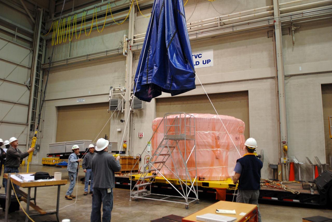 CAPE CANAVERAL, Fla. – Inside the Assembly and Refurbishment Facility, or ARF, at NASA's Kennedy Space Center in Florida, workers lift the padding away from the Ares I-X forward skirt transferred from the Astrotech facility in Titusville, Fla. The forward skirt is the initial piece of first-stage hardware in preparation for the July 2009 test flight of the agency's next-generation spacecraft and launch vehicle system. Built entirely of armored steel, the 14,000-pound segment is seven feet tall and 12-1/4 feet wide. United Space Alliance, under a subcontract to ATK, will complete the integration and assembly of the forward skirt components in the ARF. It will then be moved to the Vehicle Assembly Building high bay 3 for stacking operations. Photo credit: NASA/Tim Jacobs