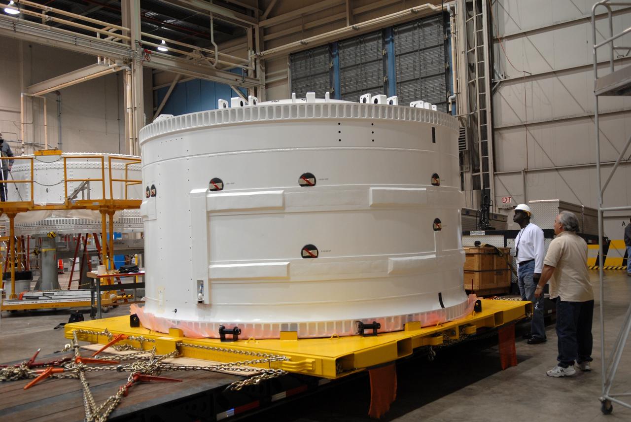 CAPE CANAVERAL, Fla. – Inside the Assembly and Refurbishment Facility, or ARF, at NASA's Kennedy Space Center in Florida, the pristine Ares I-X forward skirt is examined by workers after the protective cover was removed. The forward skirt is the initial piece of first-stage hardware in preparation for the July 2009 test flight of the agency's next-generation spacecraft and launch vehicle system. Built entirely of armored steel, the 14,000-pound segment is seven feet tall and 12-1/4 feet wide. United Space Alliance, under a subcontract to ATK, will complete the integration and assembly of the forward skirt components in the ARF. It will then be moved to the Vehicle Assembly Building high bay 3 for stacking operations. Photo credit: NASA/Tim Jacobs