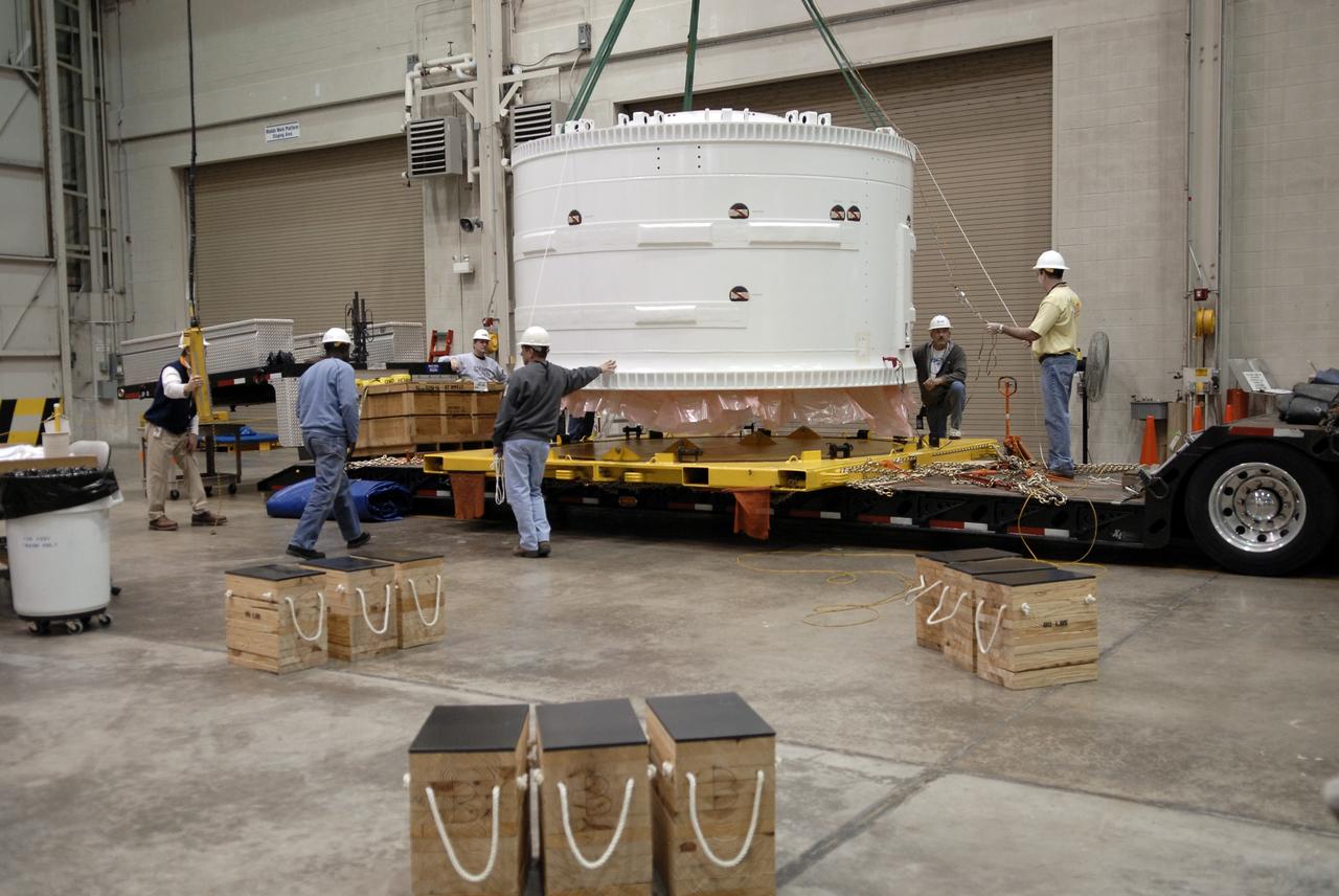 CAPE CANAVERAL, Fla. –    Inside the Assembly and Refurbishment Facility at NASA's Kennedy Space Center in Florida, the Ares I-X forward skirt is lifted off the transporter that carried it from the Astrotech facility.  The segment will be lifted off the transporter and placed on supports on the floor. United Space Alliance, under a subcontract to ATK, will complete the integration and assembly of the forward skirt components in the ARF. It will then be moved to the Vehicle Assembly Building high bay 3 for stacking operations. The forward skirt is the initial piece of first-stage hardware in preparation for the July 2009 test flight of the agency's next-generation spacecraft and launch vehicle system. Built entirely of armored steel, the 14,000-pound segment is seven feet tall and 12-1/4 feet wide.  Photo credit: NASA/Kim Shiflett
