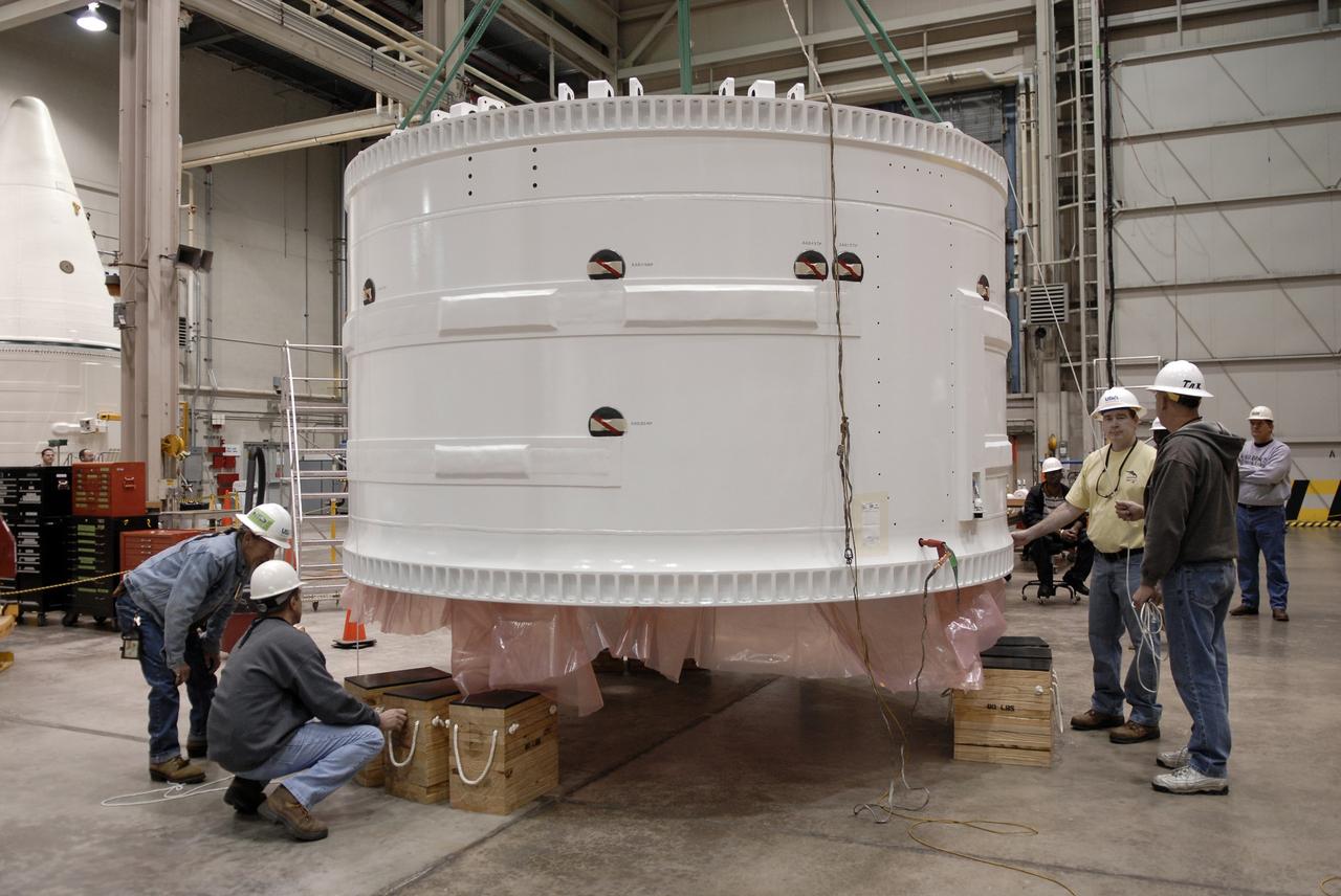 CAPE CANAVERAL, Fla. –   Inside the Assembly and Refurbishment Facility at NASA's Kennedy Space Center in Florida, the Ares I-X forward skirt is lowered onto supports on the floor.   United Space Alliance, under a subcontract to ATK, will complete the integration and assembly of the forward skirt components in the ARF. It will then be moved to the Vehicle Assembly Building high bay 3 for stacking operations. The forward skirt is the initial piece of first-stage hardware in preparation for the July 2009 test flight of the agency's next-generation spacecraft and launch vehicle system. Built entirely of armored steel, the 14,000-pound segment is seven feet tall and 12-1/4 feet wide.  Photo credit: NASA/Kim Shiflett