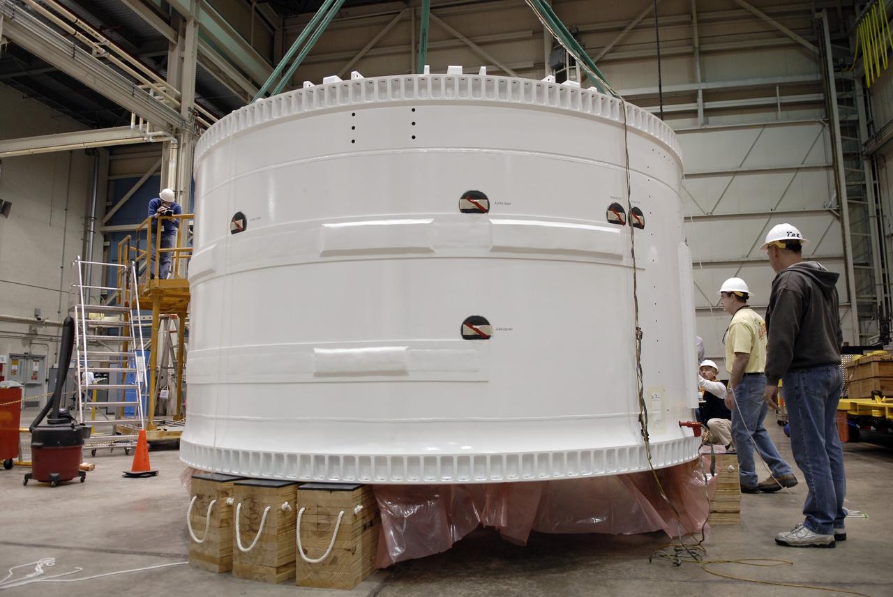 CAPE CANAVERAL, Fla. –    Inside the Assembly and Refurbishment Facility at NASA's Kennedy Space Center in Florida, the Ares I-X forward skirt is lowered onto supports on the floor. United Space Alliance, under a subcontract to ATK, will complete the integration and assembly of the forward skirt components in the ARF. It will then be moved to the Vehicle Assembly Building high bay 3 for stacking operations. The forward skirt is the initial piece of first-stage hardware in preparation for the July 2009 test flight of the agency's next-generation spacecraft and launch vehicle system. Built entirely of armored steel, the 14,000-pound segment is seven feet tall and 12-1/4 feet wide.  Photo credit: NASA/Kim Shiflett