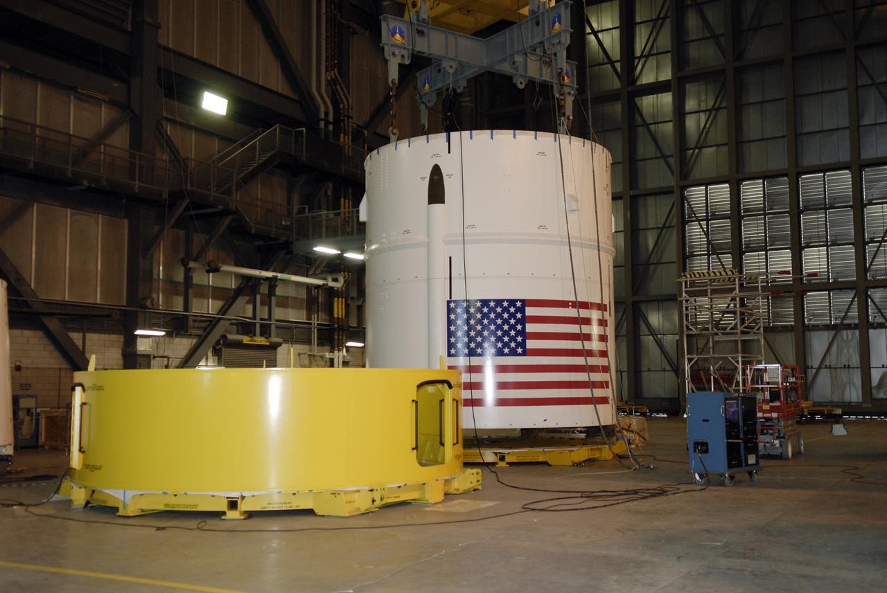 CAPE CANAVERAL, Fla. – In high bay 4 of the Vehicle Assembly Building at NASA's Kennedy Space Center in Florida, the Ares I-X segments 6 and 7 (background) are lowered onto a stand. Ares I-X is the test vehicle for the Ares I, which is part of the Constellation Program to return men to the moon and beyond. Ares I is the essential core of a safe, reliable, cost-effective space transportation system that eventually will carry crewed missions back to the moon, on to Mars and out into the solar system. Ares I may also use its 25-ton payload capacity to deliver resources and supplies to the International Space Station, or to "park" payloads in orbit for retrieval by other spacecraft bound for the moon or other destinations. The Ares I-X is targeted for launch in July 2009. Photo credit: NASA/Kim Shiflett