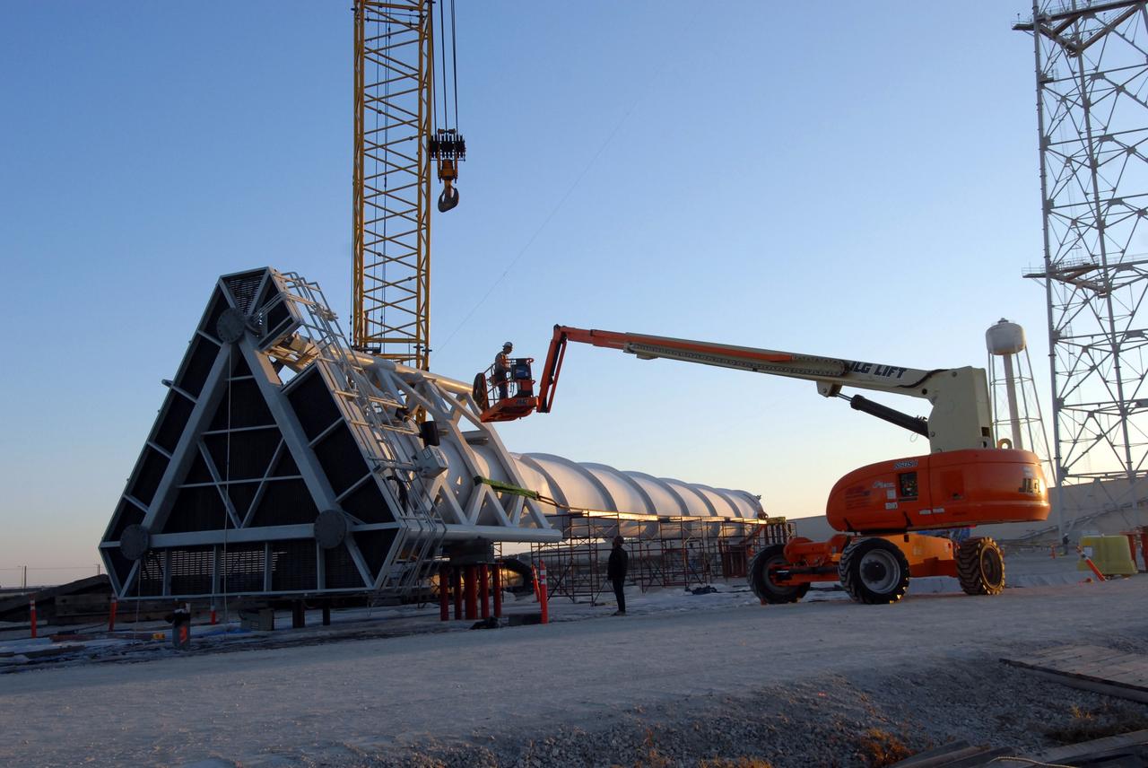 CAPE CANAVERAL, Fla. –  Construction of the towers on Launch Pad 39B at NASA's Kennedy Space Center in Florida continues on the new lightning protection system for the Constellation Program and Ares/Orion launches. Here, a 100-foot fiberglass lightning mast is being prepared to be lifted on top of one of the 500-foot towers.  The mast will support a wire catenary system. This improved lightning protection system allows for the taller height of the Ares I rocket compared to the space shuttle.  Pad 39B will be the site of the first Ares vehicle launch, including the Ares I-X test flight that is targeted for July 2009.