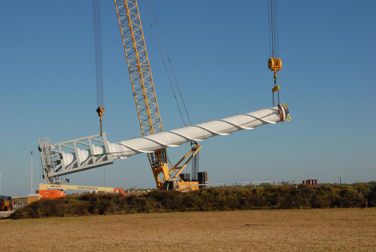 CAPE CANAVERAL, Fla. –  On Launch Pad 39B at NASA's Kennedy Space Center in Florida, a crane lifts a 100-foot fiberglass lightning mast that will be placed on top of one of the 500-foot towers being constructed for the Constellation Program and Ares/Orion launches. This improved lightning protection system allows for the taller height of the Ares I rocket compared to the space shuttle.  Pad 39B will be the site of the first Ares vehicle launch, including the Ares I-X test flight that is targeted for July 2009.
