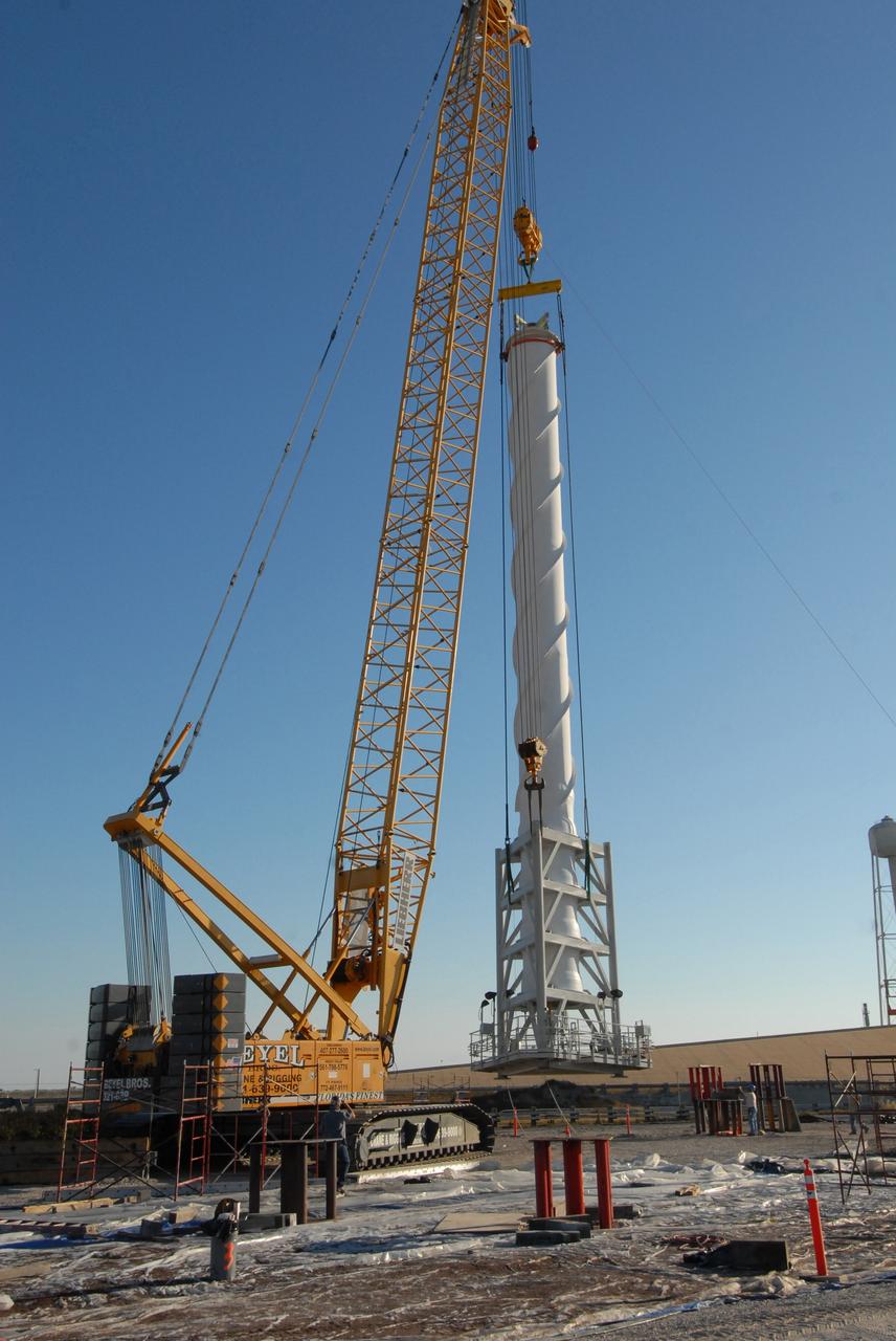 CAPE CANAVERAL, Fla. –  On Launch Pad 39B at NASA's Kennedy Space Center in Florida, a crane holds a 100-foot fiberglass lightning mast that will be placed on top of one of the 500-foot towers being constructed for the Constellation Program and Ares/Orion launches. This improved lightning protection system allows for the taller height of the Ares I rocket compared to the space shuttle.  Pad 39B will be the site of the first Ares vehicle launch, including the Ares I-X test flight that is targeted for July 2009.