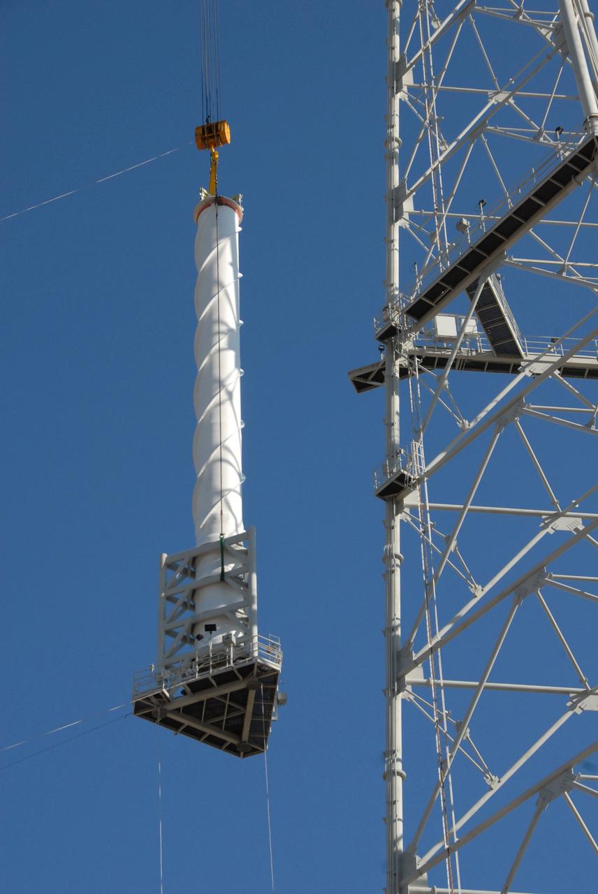 CAPE CANAVERAL, Fla. –  On Launch Pad 39B at NASA's Kennedy Space Center in Florida, a crane lifts a 100-foot fiberglass lightning mast alongside the 500-foot tower where it will be installed.  The tower is one of three being constructed for the Constellation Program and Ares/Orion launches. This improved lightning protection system allows for the taller height of the Ares I rocket compared to the space shuttle.  Pad 39B will be the site of the first Ares vehicle launch, including the Ares I-X test flight that is targeted for July 2009.