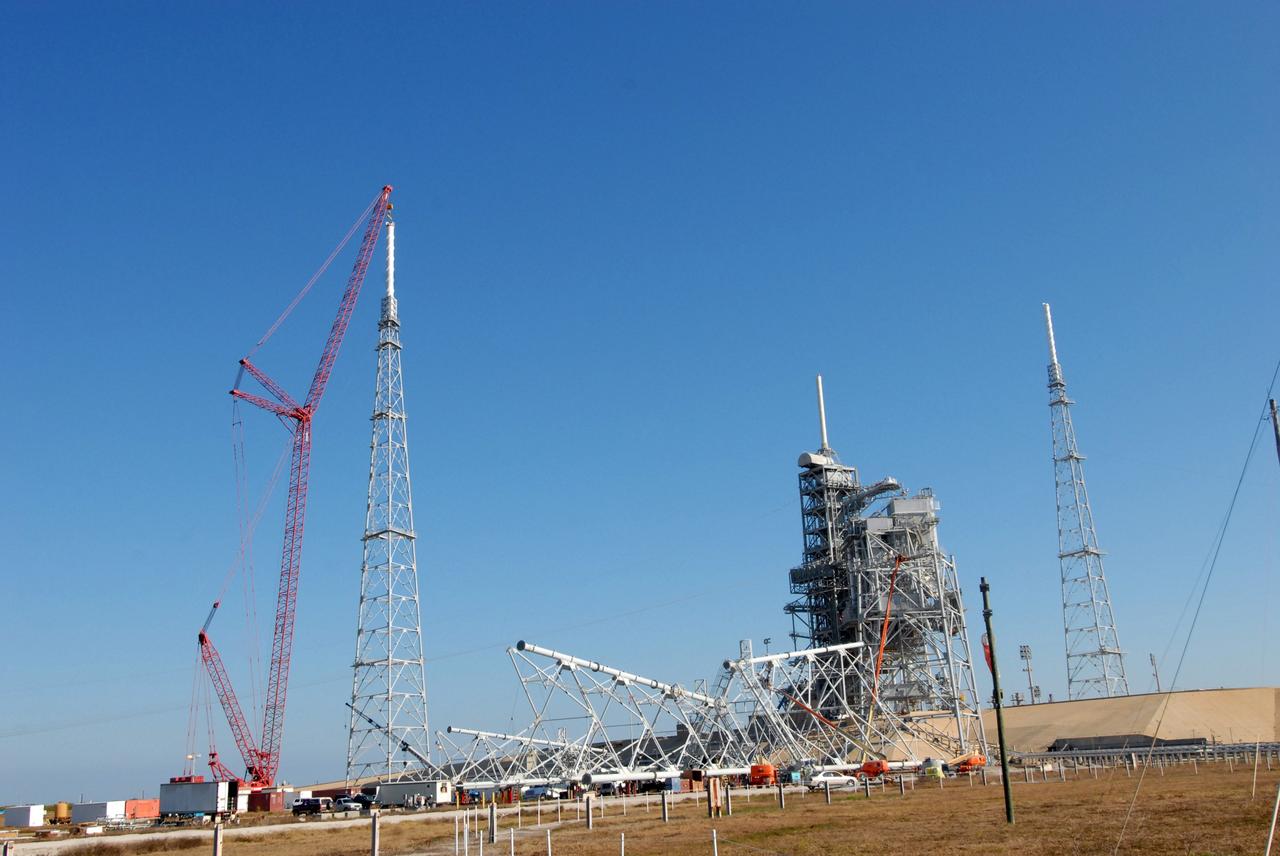 CAPE CANAVERAL, Fla. –  On Launch Pad 39B at NASA's Kennedy Space Center in Florida, a crane places a 100-foot fiberglass lightning mast on top of the 500-foot tower. The tower is one of three being constructed for the Constellation Program and Ares/Orion launches.  Another tower is seen at right. This improved lightning protection system allows for the taller height of the Ares I rocket compared to the space shuttle.  Pad 39B will be the site of the first Ares vehicle launch, including the Ares I-X test flight that is targeted for July 2009.