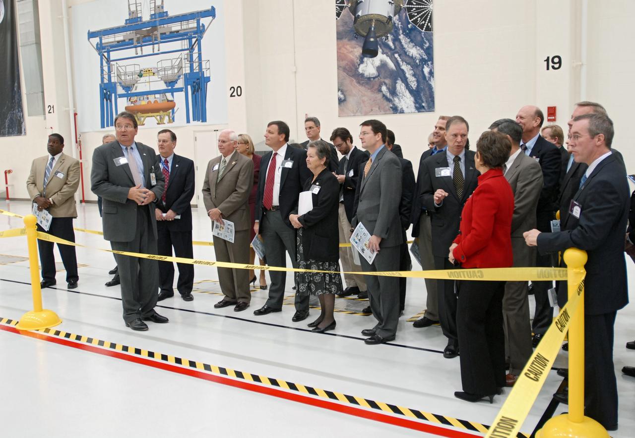 CAPE CANAVERAL, Fla. – Representatives from NASA, Lockheed Martin, Space Florida and the state of Florida participate in a ceremony at NASA's Kennedy Space Center in Florida to mark the completion of renovations on the historic Operations and Checkout Building high bay for use by the Constellation Program. At right, U.S. Rep. Suzanne Kosmas talks with U.S. Rep. Bill Posey and Center Director Robert Cabana. At far right is Steve Kohler with Space Florida. Originally built to process space vehicles in the Apollo era, the building will serve as the final assembly facility for the Orion crew exploration vehicle. Orion, America's future human spaceflight vehicle, will be capable of transporting four crew members to the moon and later will support crew transfers to Mars. The Orion spacecraft also will be used to transport crew members to the International Space Station after space shuttles are retired in 2010. The first operational launch of Orion atop an Ares I rocket is planned for 2015. Photo credit: NASA/Dimitri Gerondidakis