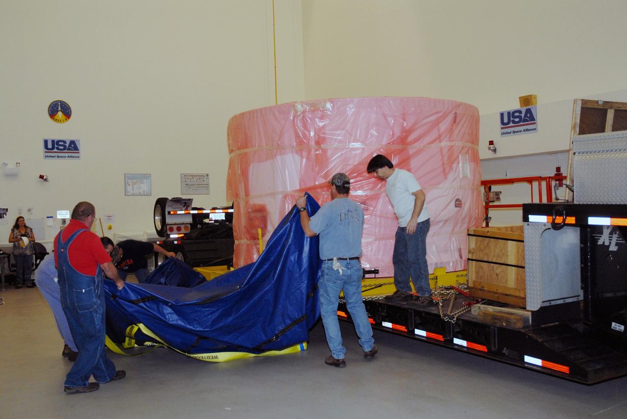 CAPE CANAVERAL, Fla. – In the Vehicle Assembly Building's extended duration orbiter lab, or EDO, at NASA's Kennedy Space Center in Florida, workers remove the shipping cover from the fifth segment simulator of the Ares I-X. Ares I-X is the test vehicle for the Ares I, which is part of the Constellation Program to return men to the moon and beyond. Ares I is the essential core of a safe, reliable, cost-effective space transportation system that eventually will carry crewed missions back to the moon, on to Mars and out into the solar system. Ares I-X is targeted for launch in July 2009. Photo credit: NASA/Tim Jacobs