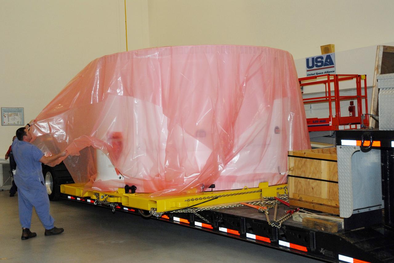 CAPE CANAVERAL, Fla. – In the Vehicle Assembly Building at NASA's Kennedy Space Center in Florida, workers begin removing the protective material wrapping the fifth segment simulator of the Ares I-X. Ares I-X is the test vehicle for the Ares I, which is part of the Constellation Program to return men to the moon and beyond. Ares I is the essential core of a safe, reliable, cost-effective space transportation system that eventually will carry crewed missions back to the moon, on to Mars and out into the solar system. Ares I-X is targeted for launch in July 2009. Photo credit: NASA/Tim Jacobs