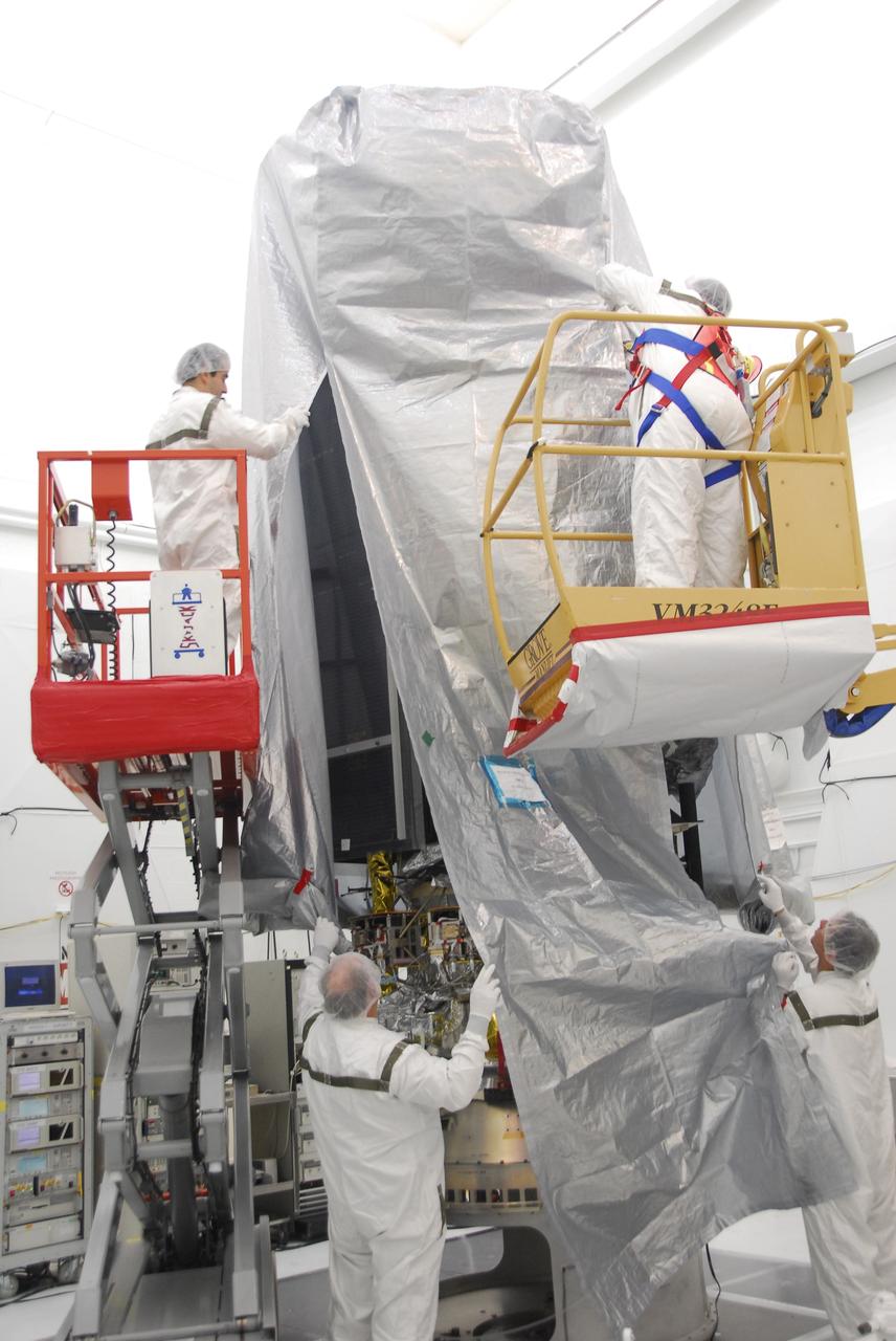 VANDENBERG AIR FORCE BASE, Calif. –  In the NASA payload processing facility at Vandenberg Air Force Base in California, workers place a protective cover around the NOAA-N Prime satellite before moving it. NOAA-N Prime is the latest polar-orbiting operational environmental weather satellite developed by NASA for the National Oceanic and Atmospheric Administration.  It is built by Lockheed Martin and similar to NOAA-N launched on May 20, 2005. Launch of NOAA-N Prime is scheduled for Feb. 4.   Photo credit: NASA/Robert Hargreaves Jr., VAFB