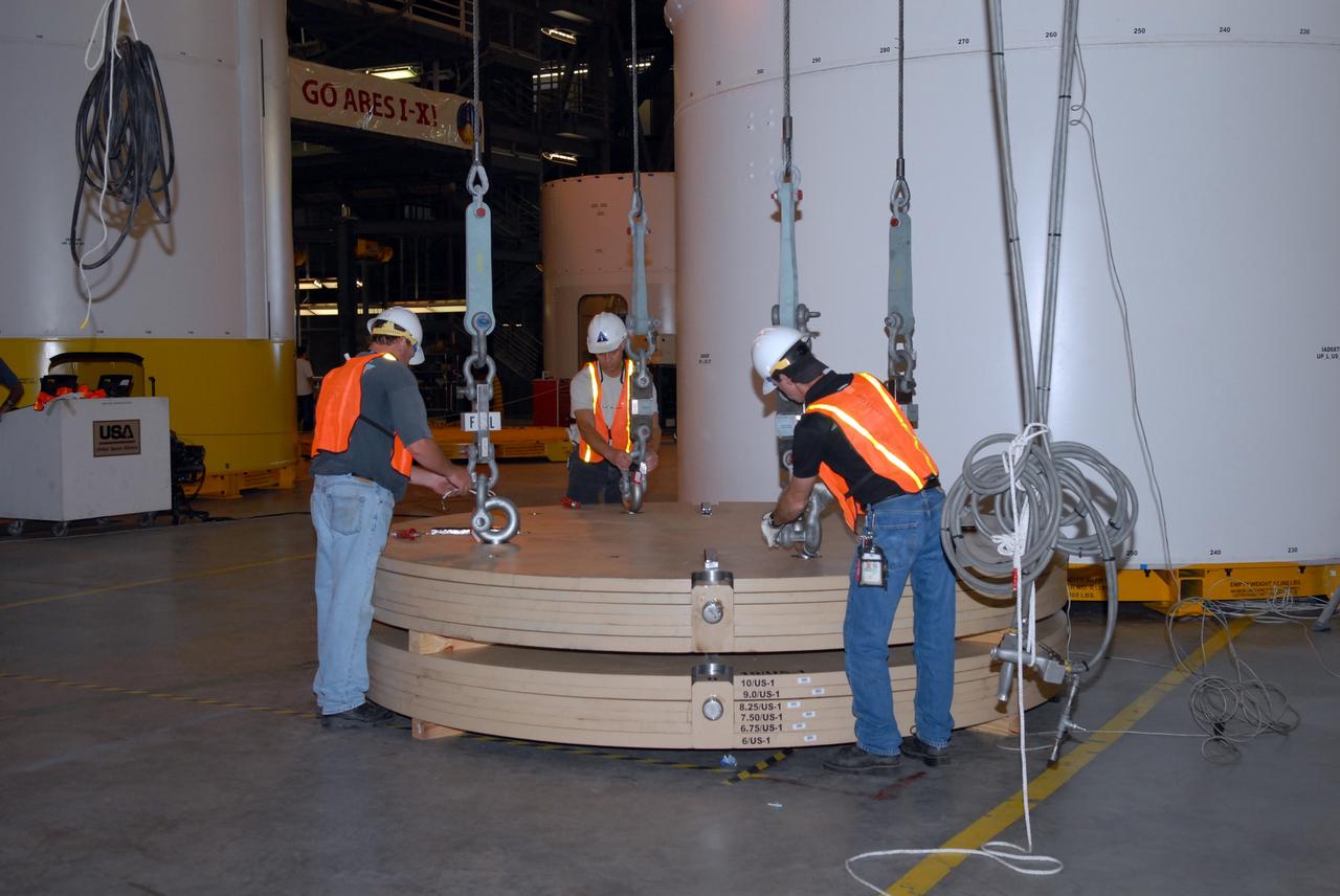 CAPE CANAVERAL, Fla. –  In Vehicle Assembly Building high bay 4, workers attached cables to ballast that will be installed in segment 7 for the Ares I-X  rocket. These ballast assemblies are being installed in the upper stage segments 1 and 7 and will mimic the mass of the fuel. Their total weight is approximately 160,000 pounds. Ares I-X  is the test vehicle for the Ares I, which is part of the Constellation Program to return men to the moon and beyond.  Ares I is the essential core of a safe, reliable, cost-effective space transportation system that eventually will carry crewed missions back to the moon, on to Mars and out into the solar system. The Ares I-X  is targeted for launch in July 2009.  Photo credit: NASA/Jack Pfaller