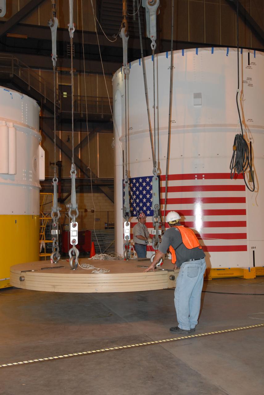 CAPE CANAVERAL, Fla. –  In Vehicle Assembly Building high bay 4, cables lift ballast that will be installed in segment 7 for the Ares I-X  rocket. These ballast assemblies are being installed in the upper stage segments 1 and 7 and will mimic the mass of the fuel. Their total weight is approximately 160,000 pounds. Ares I-X  is the test vehicle for the Ares I, which is part of the Constellation Program to return men to the moon and beyond.  Ares I is the essential core of a safe, reliable, cost-effective space transportation system that eventually will carry crewed missions back to the moon, on to Mars and out into the solar system. The Ares I-X  is targeted for launch in July 2009.  Photo credit: NASA/Jack Pfaller