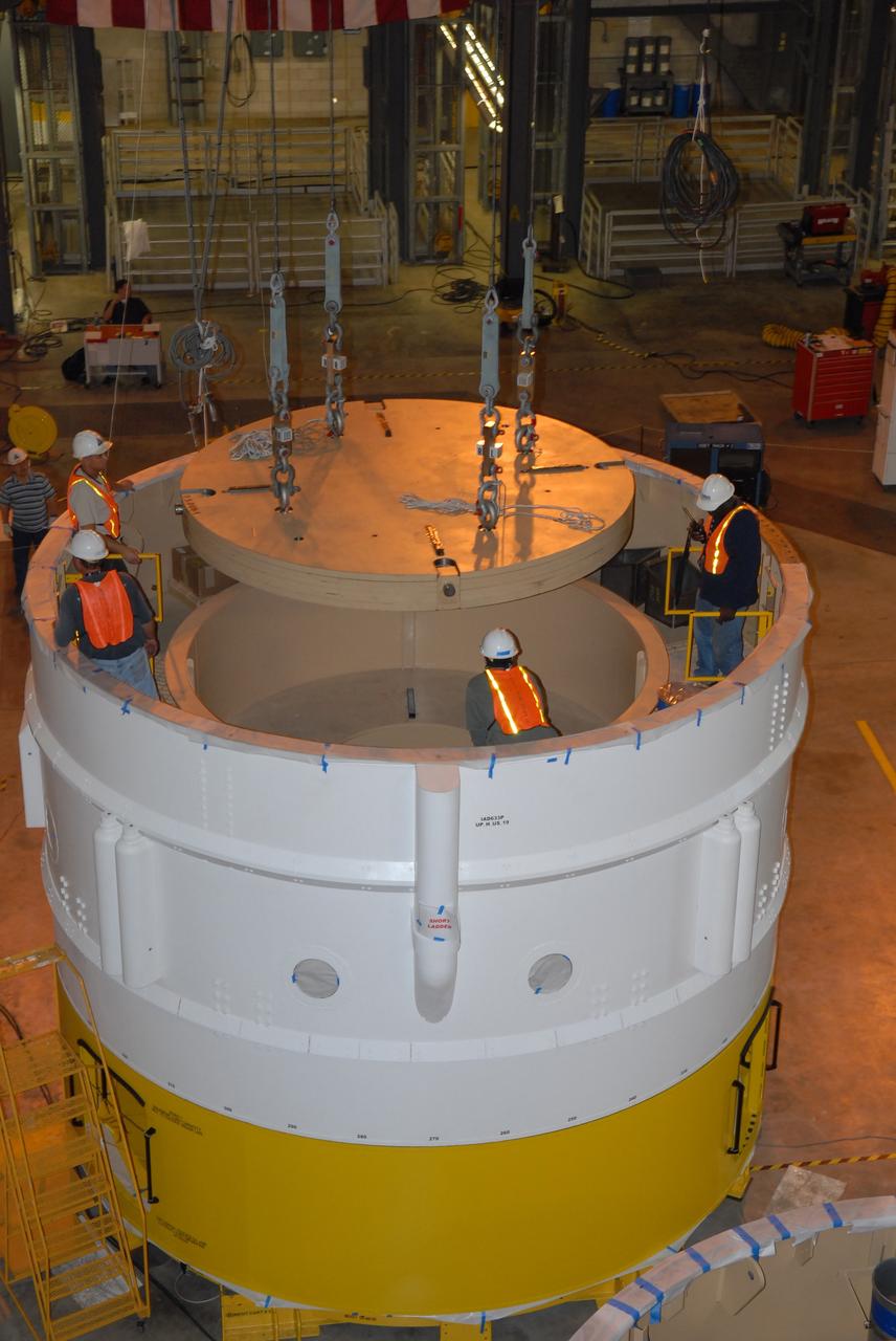 CAPE CANAVERAL, Fla. –   In Vehicle Assembly Building high bay 4, cables from an overhead crane lower ballast into segment 7 for the Ares I-X  rocket. These ballast assemblies are being installed in the upper stage segments 1 and 7 and will mimic the mass of the fuel. Their total weight is approximately 160,000 pounds.  Ares I-X  is the test vehicle for the Ares I, which is part of the Constellation Program to return men to the moon and beyond.  Ares I is the essential core of a safe, reliable, cost-effective space transportation system that eventually will carry crewed missions back to the moon, on to Mars and out into the solar system. The Ares I-X  is targeted for launch in July 2009.  Photo credit: NASA/Jack Pfaller