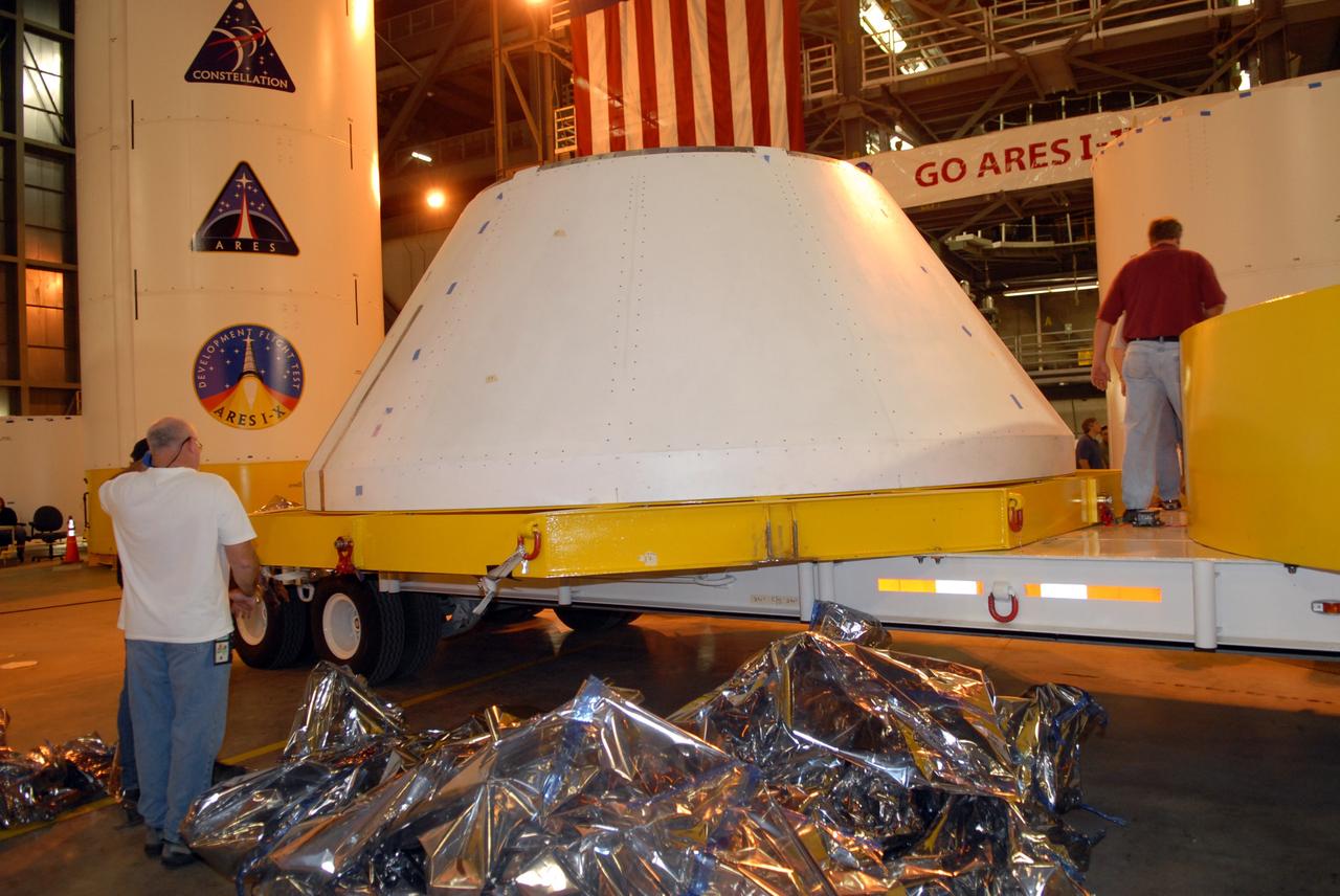 CAPE CANAVERAL, Fla. – In the Vehicle Assembly Building's high bay 4 at NASA's Kennedy Space Center in Florida, the protective blue cover is removed from the simulator crew module for the Ares I-X rocket. The precisely machined, full-scale simulator crew module is part of the hardware that will be used in the launch of the rocket. Also arriving is a launch abort system that, with the module, will form the tip of the rocket. Ares I-X is the test flight for the Ares I. The I-X flight will provide NASA an early opportunity to test and prove hardware, facilities and ground operations associated with Ares I. The launch of the 321-foot-tall, full-scale Ares I-X, targeted for July 2009, will be the first in a series of unpiloted rocket launches from Kennedy. When fully developed, the 16-foot diameter crew module will furnish living space and reentry protection for the astronauts, while their launch abort system will provide safe evacuation if a launch vehicle failure occurs. Photo credit: NASA/Jack Pfaller