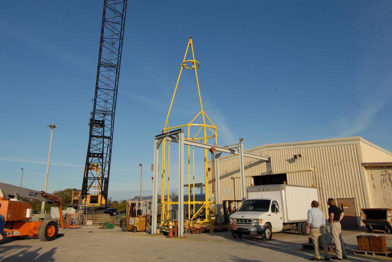 CAPE CANAVERAL, Fla. –   The yellow framework at center is the lifting fixture nicknamed the "Birdcage" that will have the ability to lift the Crew Module, or CM, and Launch Abort System, or LAS, assembly for the Ares I-X rocket and to stack and de-stack the assembly from the Service Module/Spacecraft Adapter assembly.  It will also have the ability to lift and to stack and de-stack Stack-5  (all of the above components) from the Ares I-X flight test vehicle in the Vehicle Assembly Building at NASA's Kennedy Space Center in Florida. Ares I-X is the test flight for the Ares I.   The I-X flight will provide NASA an early opportunity to test and prove hardware, facilities and ground operations associated with Ares I. The launch of the 321-foot-tall, full-scale Ares I-X, targeted for July 2009, will be the first in a series of unpiloted rocket launches from Kennedy. When fully developed, the 16-foot diameter crew module will furnish living space and reentry protection for the astronauts, while their launch abort system will provide safe evacuation if a launch vehicle failure occurs.   Photo credit: NASA/Jack Pfaller