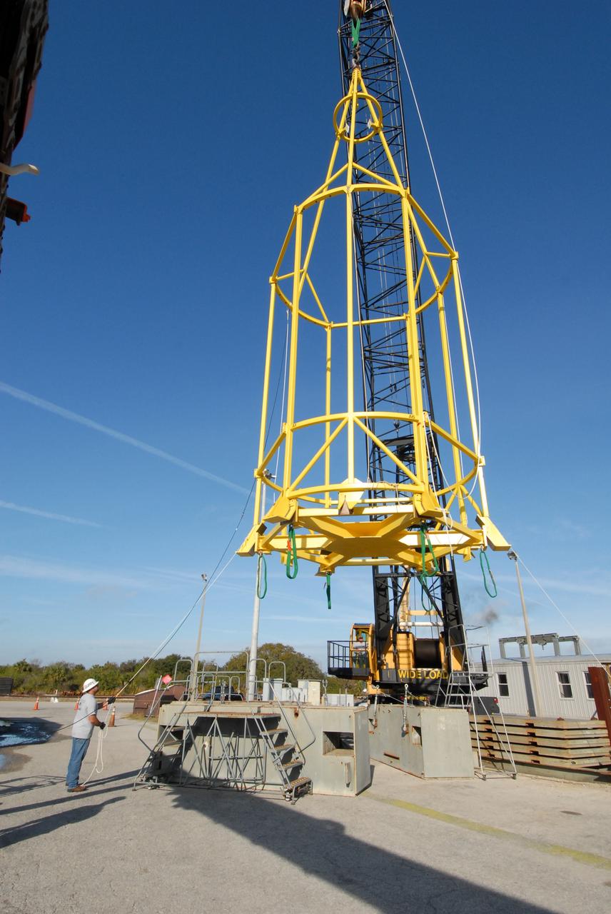 CAPE CANAVERAL, Fla. –  The lifting fixture nicknamed the "Birdcage" is lifted by a crane to test the load capability.  The Birdcage will be used to lift the Crew Module, or CM, and Launch Abort System, or LAS, assembly for the Ares I-X rocket and to stack and de-stack the assembly from the Service Module/Spacecraft Adapter assembly.  It will also have the ability to lift and to stack and de-stack Stack-5  (all of the above components) from the Ares I-X in the Vehicle Assembly Building at NASA's Kennedy Space Center in Florida. Ares I-X is the test flight for the Ares I.   The I-X flight will provide NASA an early opportunity to test and prove hardware, facilities and ground operations associated with Ares I. The launch of the 321-foot-tall, full-scale Ares I-X, targeted for July 2009, will be the first in a series of unpiloted rocket launches from Kennedy. When fully developed, the 16-foot diameter crew module will furnish living space and reentry protection for the astronauts, while their launch abort system will provide safe evacuation if a launch vehicle failure occurs.   Photo credit: NASA/Jack Pfaller