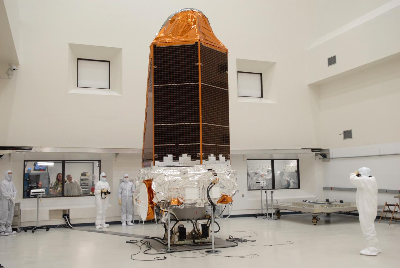 CAPE CANAVERAL, Fla. – NASA's Kepler spacecraft, that will be launched in March aboard a United Launch Alliance Delta II rocket, is photographed by journalists dressed in clean-room suits. Visible are the solar arrays on top and the high-gain antenna at lower left. The event, being held at the Astrotech Space Operations facility in Titusville, Fla., provides media representatives an opportunity to photograph the space telescope and to interview project officials from NASA and Ball Aerospace, builder of the spacecraft. Kepler is designed to survey more that 100,000 stars in our galaxy to determine the number of sun-like stars that have Earth-size and larger planets, including those that lie in a star's "habitable zone," a region where liquid water, and perhaps life, could exist. If these Earth-size worlds do exist around stars like our sun, Kepler is expected to be the first to find them and the first to measure how common they are. The liftoff of Kepler aboard a Delta II rocket is currently planned for 10:48 p.m. EST March 5 from Space Launch Complex 17 on Cape Canaveral Air Force Station. Photo credit: NASA/Troy Cryder