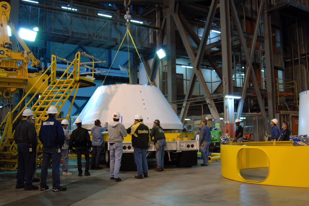 CAPE CANAVERAL, Fla. –     In high bay 4 of the Vehicle Assembly Building at NASA's Kennedy Space Center in Florida, the newly arrived simulator crew module for the Ares I-X rocket is lifted off the truck.  The module will be moved to a work stand. Ares I-X is the test flight for the Ares I.  The I-X flight will provide NASA an early opportunity to test and prove hardware, facilities and ground operations associated with Ares I. The launch of the 321-foot-tall, full-scale Ares I-X, targeted for July 2009, will be the first in a series of unpiloted rocket launches from Kennedy. When fully developed, the 16-foot diameter crew module will furnish living space and reentry protection for the astronauts.  Photo credit: NASA/Jack Pfaller