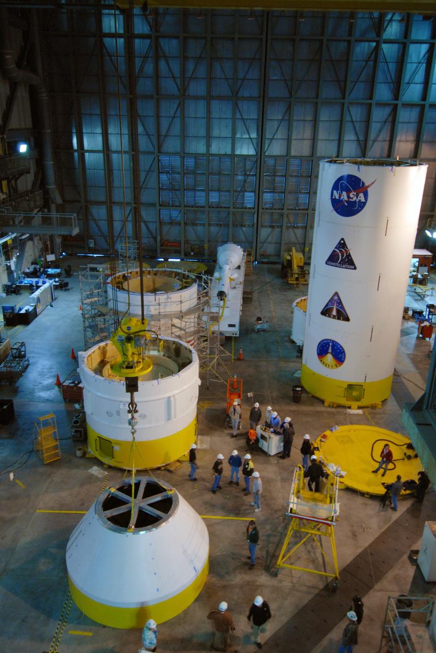 CAPE CANAVERAL, Fla. –   In high bay 4 of the Vehicle Assembly Building at NASA's Kennedy Space Center in Florida, the newly arrived simulator crew module for the Ares I-X rocket rests on a work stand, surrounded by other segments stacked on the floor. Ares I-X is the test flight for the Ares I.  The I-X flight will provide NASA an early opportunity to test and prove hardware, facilities and ground operations associated with Ares I. The launch of the 321-foot-tall, full-scale Ares I-X, targeted for July 2009, will be the first in a series of unpiloted rocket launches from Kennedy. When fully developed, the 16-foot diameter crew module will furnish living space and reentry protection for the astronauts.  Photo credit: NASA/Jack Pfaller