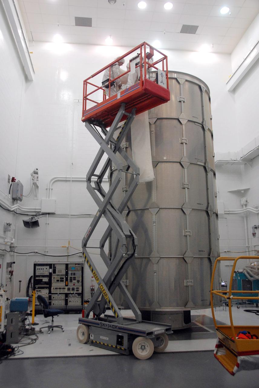 VANDENBERG AIR FORCE BASE, Calif. --  In Bldg. 1610 at Vandenberg Air Force Base in California, workers begin attaching a protective cover over the transportation cover of the NOAA-N Prime spacecraft. The spacecraft will be moved to a transporter. NOAA-N Prime is the latest polar-orbiting operational environmental weather satellite developed by NASA for the National Oceanic and Atmospheric Administration.  The satellite is scheduled to launch Feb. 4 aboard a Delta II rocket from Vandenberg Air Force Base. Photo credit: NASA/ Daniel Liberotti, VAFB