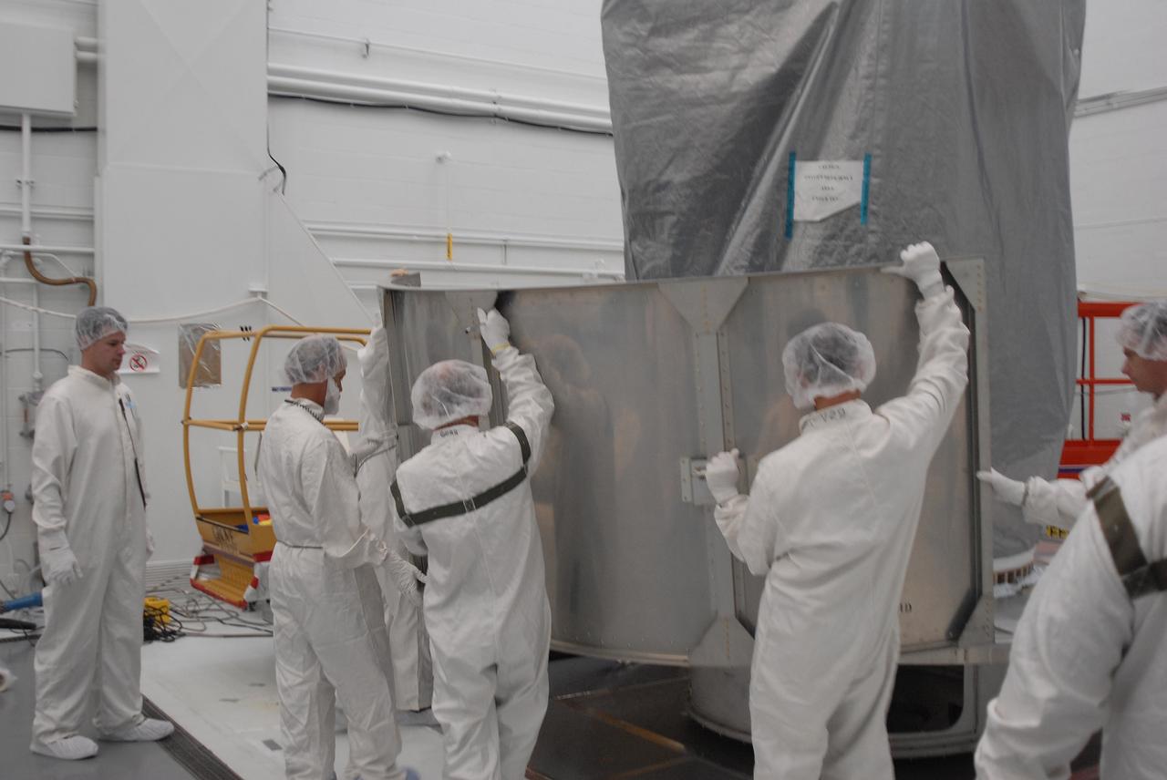 VANDENBERG AIR FORCE BASE, Calif. --   In Bldg. 1610 at Vandenberg Air Force Base in California, workers place the first of the lower segments of a transportation canister around the NOAA-N Prime spacecraft.  NOAA-N Prime is the latest polar-orbiting operational environmental weather satellite developed by NASA for the National Oceanic and Atmospheric Administration.  The satellite is scheduled to launch Feb. 4 aboard a Delta II rocket from Vandenberg Air Force Base. Photo credit: NASA/ Daniel Liberotti, VAFB