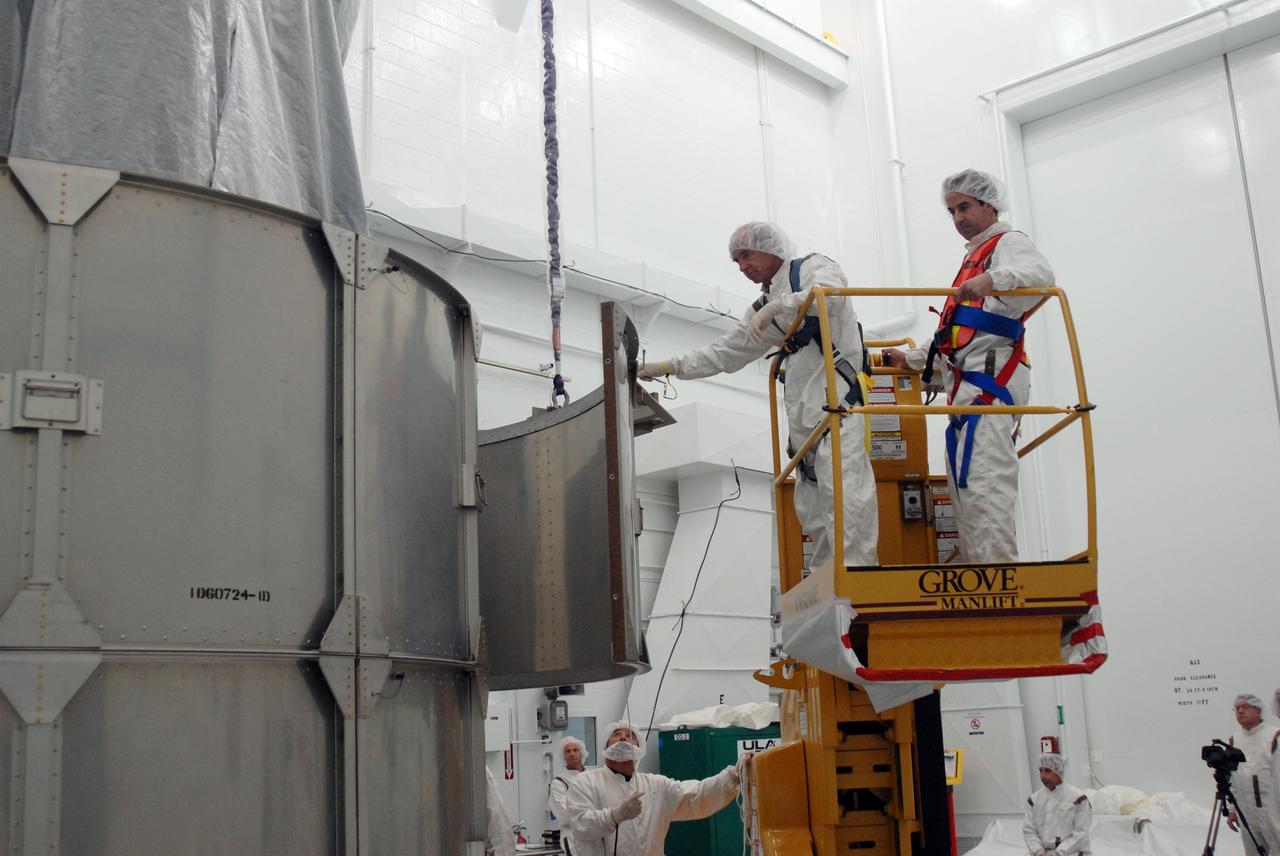 VANDENBERG AIR FORCE BASE, Calif. --  In Bldg. 1610 at Vandenberg Air Force Base in California, workers guide an upper segment of the transportation canister toward the NOAA-N Prime spacecraft.  NOAA-N Prime is the latest polar-orbiting operational environmental weather satellite developed by NASA for the National Oceanic and Atmospheric Administration.  The satellite is scheduled to launch Feb. 4 aboard a Delta II rocket from Vandenberg Air Force Base. Photo credit: NASA/ Daniel Liberotti, VAFB