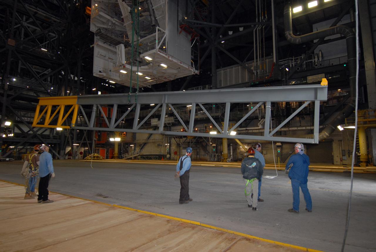 CAPE CANAVERAL, Fla. – In the Vehicle Assembly Building at NASA's Kennedy Space Center in Florida, an upper rail removed from high bay 3 is lowered onto the floor.  The removal is part of the modifications for the Constellation Program's Ares vehicles.  The Ares I and Ares V rockets will be 325 feet and 360 feet tall, respectively, considerably taller than the space shuttle atop its mobile launcher platform.   Photo credit: NASA/Jack Pfaller