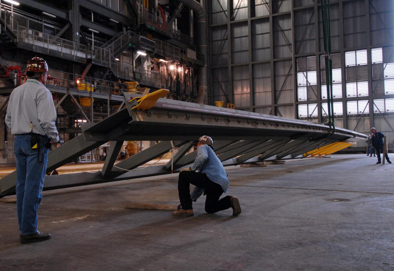 CAPE CANAVERAL, Fla. – In the Vehicle Assembly Building at NASA's Kennedy Space Center in Florida, an upper rail removed from high bay 3 is lowered onto the floor.  The removal is part of the modifications for the Constellation Program's Ares vehicles.  The Ares I and Ares V rockets will be 325 feet and 360 feet tall, respectively, considerably taller than the space shuttle atop its mobile launcher platform.   Photo credit: NASA/Jack Pfaller