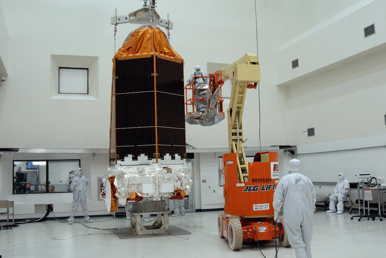 CAPE CANAVERAL, Fla. – At the Astrotech payload processing facility, an overhead crane lifts NASA's Kepler spacecraft from a work stand. Kepler will be moved to a mobile stand to be covered and moved to the Hazardous Processing Facility for fueling. Kepler is designed to survey more than 100,000 stars in our galaxy to determine the number of sun-like stars that have Earth-size and larger planets, including those that lie in a star's "habitable zone," a region where liquid water, and perhaps life, could exist. If these Earth-size worlds do exist around stars like our sun, Kepler is expected to be the first to find them and the first to measure how common they are. The liftoff of Kepler aboard a Delta II rocket is currently planned for 10:48 p.m. EST March 5 from Space Launch Complex 17 on Cape Canaveral Air Force Station. Photo credit: NASA/Jack Pfaller