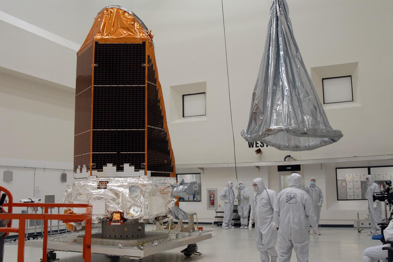 CAPE CANAVERAL, Fla. – At the Astrotech payload processing facility, the protective cover at right is lifted toward NASA's Kepler spacecraft at left. When covered, Kepler will be moved to the Hazardous Processing Facility for fueling. Kepler is designed to survey more than 100,000 stars in our galaxy to determine the number of sun-like stars that have Earth-size and larger planets, including those that lie in a star's "habitable zone," a region where liquid water, and perhaps life, could exist. If these Earth-size worlds do exist around stars like our sun, Kepler is expected to be the first to find them and the first to measure how common they are. The liftoff of Kepler aboard a Delta II rocket is currently planned for 10:48 p.m. EST March 5 from Space Launch Complex 17 on Cape Canaveral Air Force Station. Photo credit: NASA/Jack Pfaller