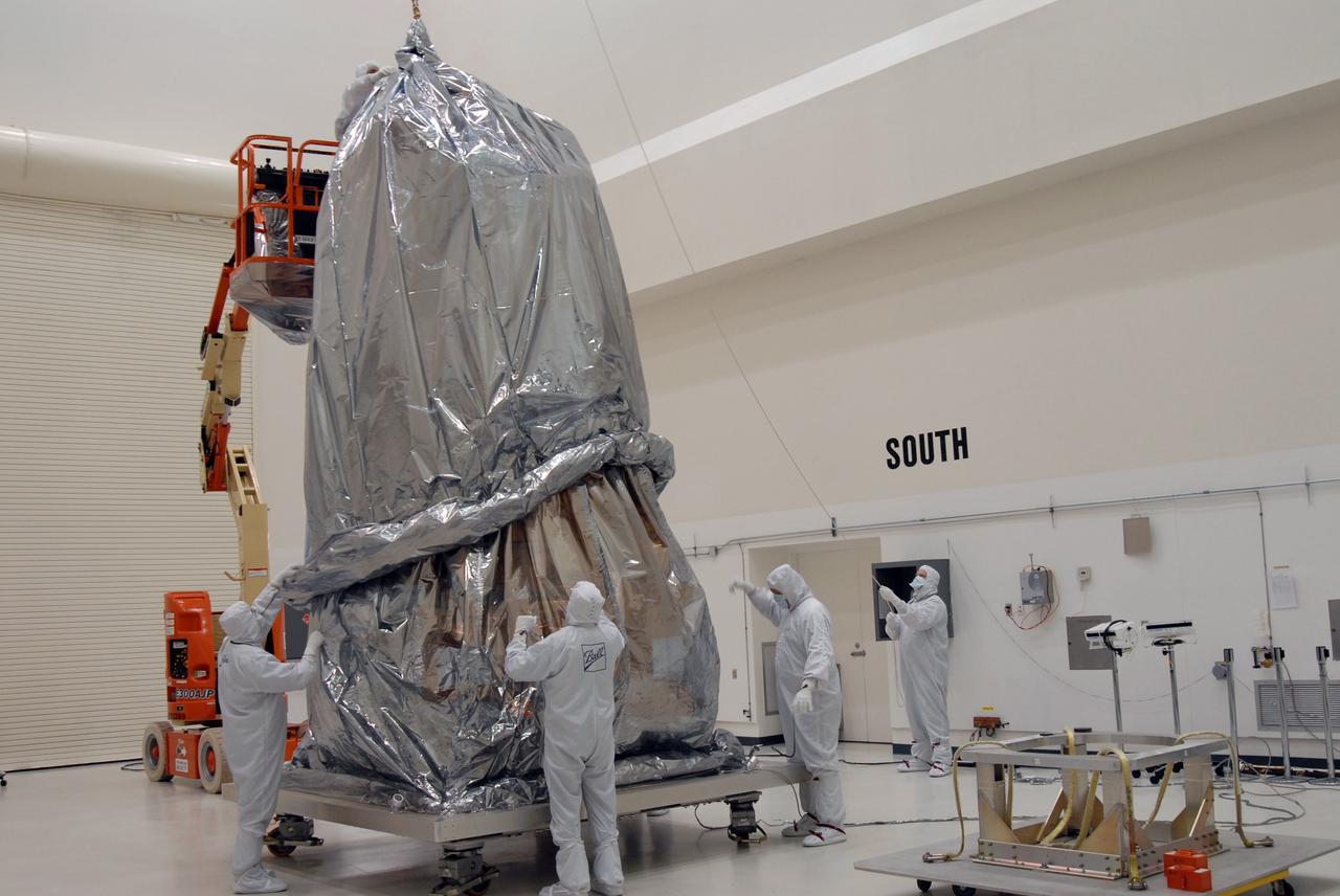 CAPE CANAVERAL, Fla. – At the Astrotech payload processing facility, the second cover is placed over NASA's Kepler spacecraft. Kepler will be moved to the Hazardous Processing Facility for fueling. Kepler is designed to survey more than 100,000 stars in our galaxy to determine the number of sun-like stars that have Earth-size and larger planets, including those that lie in a star's "habitable zone," a region where liquid water, and perhaps life, could exist. If these Earth-size worlds do exist around stars like our sun, Kepler is expected to be the first to find them and the first to measure how common they are. The liftoff of Kepler aboard a Delta II rocket is currently planned for 10:48 p.m. EST March 5 from Space Launch Complex 17 on Cape Canaveral Air Force Station. Photo credit: NASA/Jack Pfaller