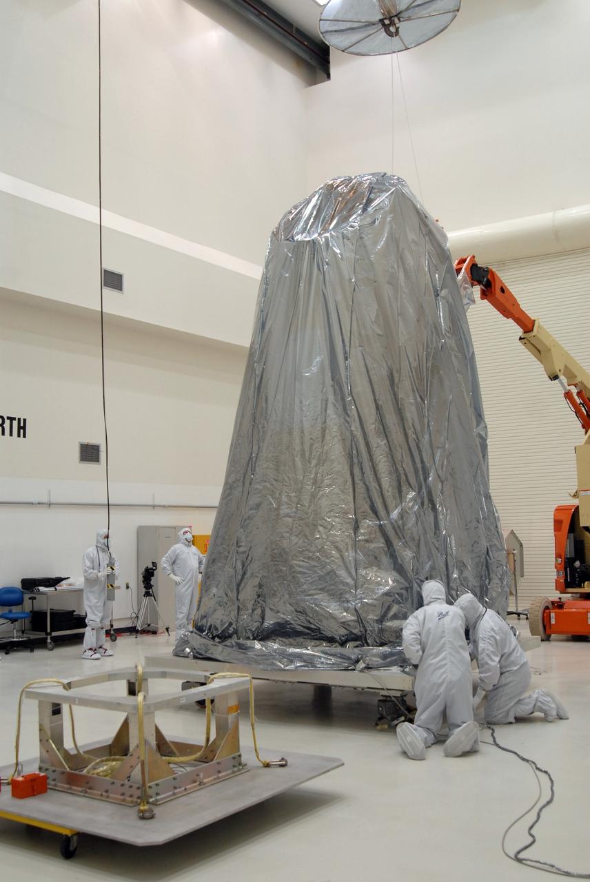 CAPE CANAVERAL, Fla. – At the Astrotech payload processing facility, technicians secure the protective cover over NASA's Kepler spacecraft. Kepler will be moved to the Hazardous Processing Facility for fueling. Kepler is designed to survey more than 100,000 stars in our galaxy to determine the number of sun-like stars that have Earth-size and larger planets, including those that lie in a star's "habitable zone," a region where liquid water, and perhaps life, could exist. If these Earth-size worlds do exist around stars like our sun, Kepler is expected to be the first to find them and the first to measure how common they are. The liftoff of Kepler aboard a Delta II rocket is currently planned for 10:48 p.m. EST March 5 from Space Launch Complex 17 on Cape Canaveral Air Force Station. Photo credit: NASA/Jack Pfaller