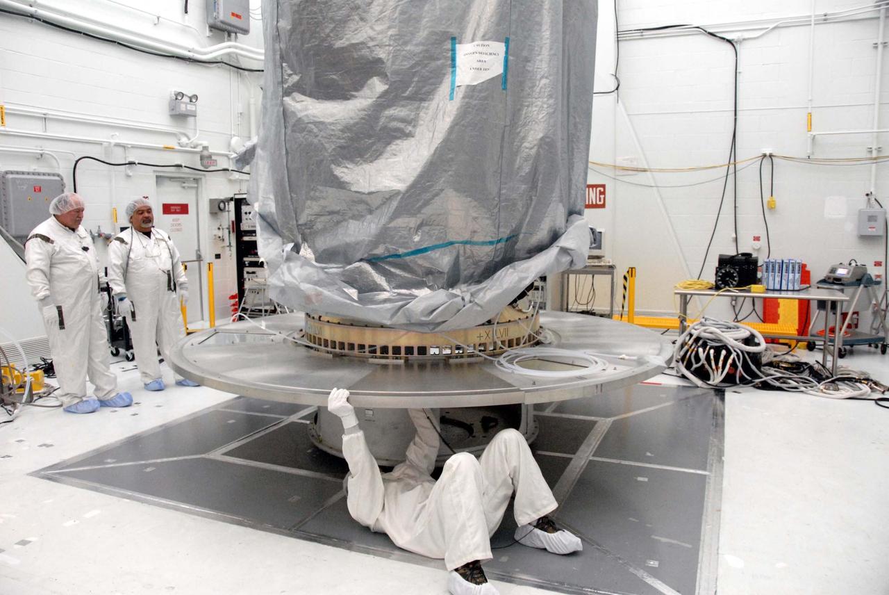VANDENBERG AIR FORCE BASE, Calif. – In Building 1610 at Vandenberg Air Force Base in California, the United Launch Alliance direct mate adapter, or DMA, is installed on the NOAA-N Prime's payload attach fitting underneath the spacecraft.  The DMA is needed to install the payload canister around the spacecraft for the journey to the launch pad. NOAA-N Prime is the latest polar-orbiting operational environmental weather satellite developed by NASA for the National Oceanic and Atmospheric Administration. Launch of NOAA-N Prime is scheduled for Feb. 4.  Photo credit: NASA/Doug Kolkow, VAFB