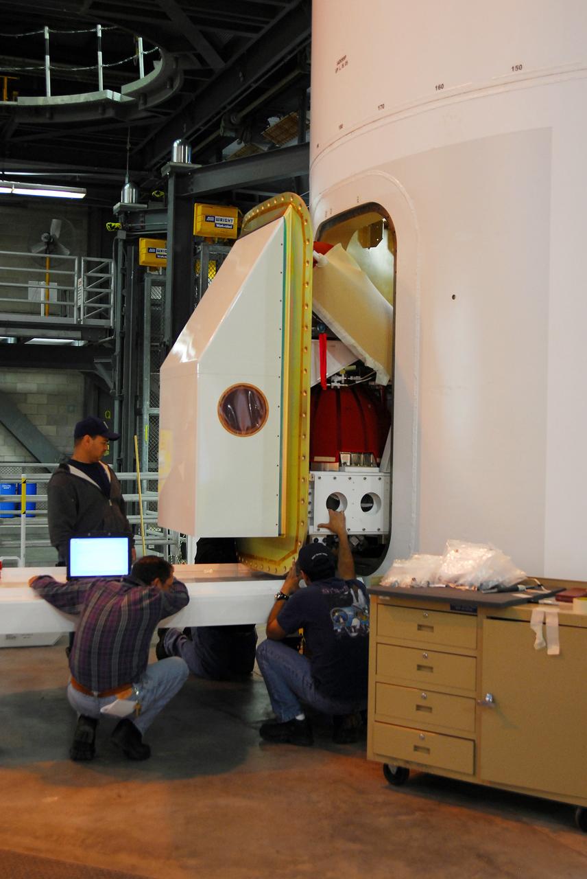 CAPE CANAVERAL, Fla. – One of the Ares I-X roll control system modules is moved into place on the upper stage simulator for a fit check. The hardware is in high bay 4 of the Vehicle Assembly Building at NASA's Kennedy Space Center. The system is designed to perform a 90-degree roll after the rocket clears the launch tower, preventing a roll during flight and maintaining the orientation of the rocket until separation of the upper and first stages. The system module will return to earth and splash down; it will not be recovered. Ares I-X is the test vehicle for the Ares I, which is part of the Constellation Program to return men to the moon and beyond. Ares I-X is targeted for launch in summer of 2009. Photo credit: NASA/Tim Jacobs