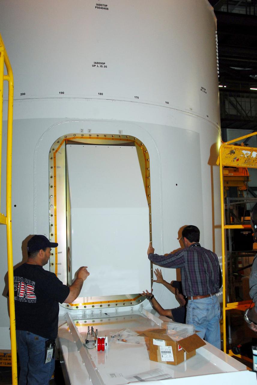 CAPE CANAVERAL, Fla. – One of the Ares I-X roll control system modules is moved into place on the upper stage simulator for a fit check. The hardware is in high bay 4 of the Vehicle Assembly Building at NASA's Kennedy Space Center. The system is designed to perform a 90-degree roll after the rocket clears the launch tower, preventing a roll during flight and maintaining the orientation of the rocket until separation of the upper and first stages. The system module will return to earth and splash down; it will not be recovered. Ares I-X is the test vehicle for the Ares I, which is part of the Constellation Program to return men to the moon and beyond. Ares I-X is targeted for launch in summer of 2009. Photo credit: NASA/Tim Jacobs