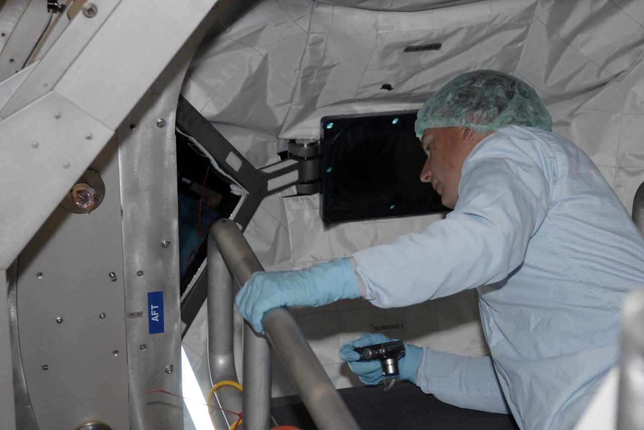 CAPE CANAVERAL, Fla. – In the Space Station Processing Facility, STS-130 Pilot Terry Virts Jr. moves closer to the Cupola, part of the payload on the mission to the International Space Station, to get a better look. The seven-windowed module will be used as a control room for robotics on the station. Endeavour will also deliver the final connecting node, Node 3.  Photo credit: NASA/Kim Shiflett