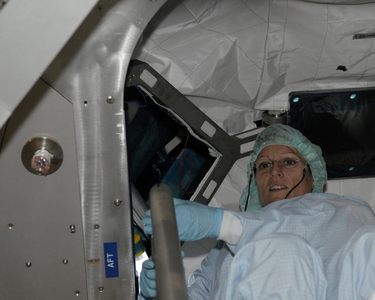CAPE CANAVERAL, Fla. – In the Space Station Processing Facility, STS-130 Mission Specialist Kathryn Hire sits inside the Cupola, part of the payload on the mission to the International Space Station. The seven-windowed module will be used as a control room for robotics on the station. Endeavour will also deliver the final connecting node, Node 3.  Photo credit: NASA/Kim Shiflett