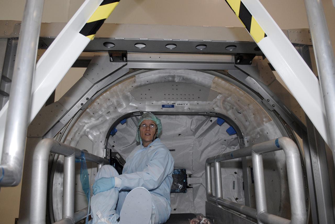 CAPE CANAVERAL, Fla. – In the Space Station Processing Facility, STS-130 Mission Specialist Kathryn Hire sits inside the Cupola, part of the payload on the mission to the International Space Station.  The seven-windowed module will be used as a control room for robotics on the station. Endeavour will also deliver the final connecting node, Node 3.  Photo credit: NASA/Kim Shiflett